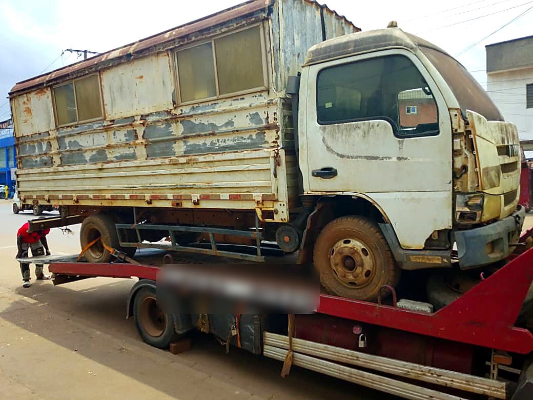 Petit camion à caisse en panne chargé sur le plateau d'une dépanneuse Remorquage237 à Yaoundé